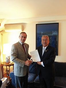 ギリシャ共和国大使館でルカス・カラツォリス大使（左）と木津市長（右）が書類を持ち、握手を交わしている写真