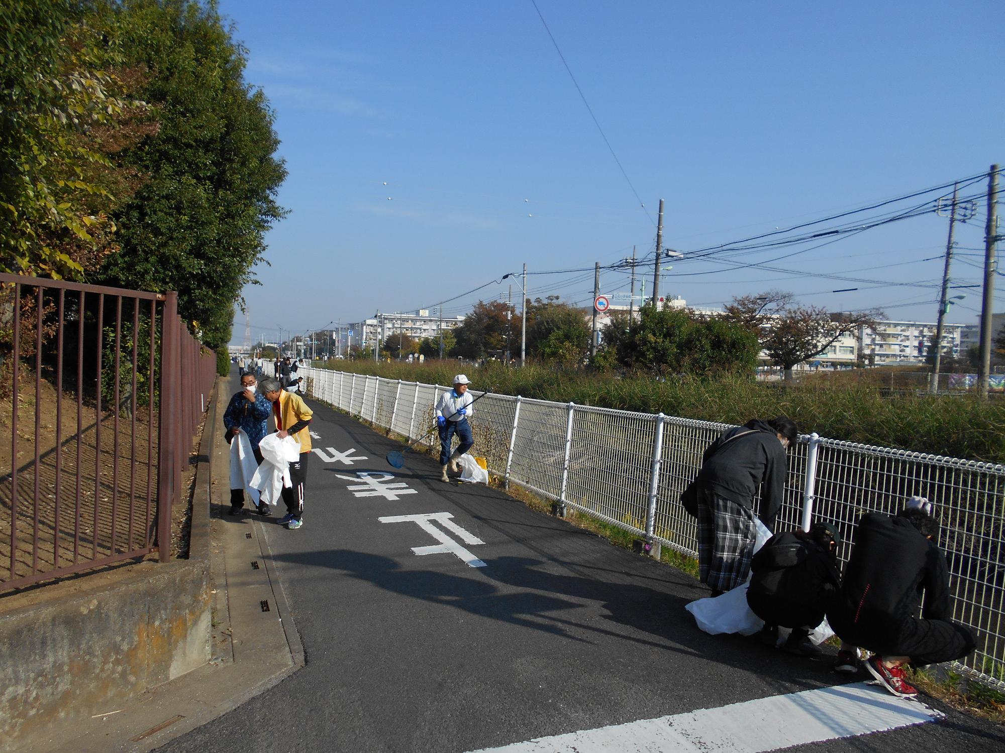 川沿いのゴミを拾っている写真