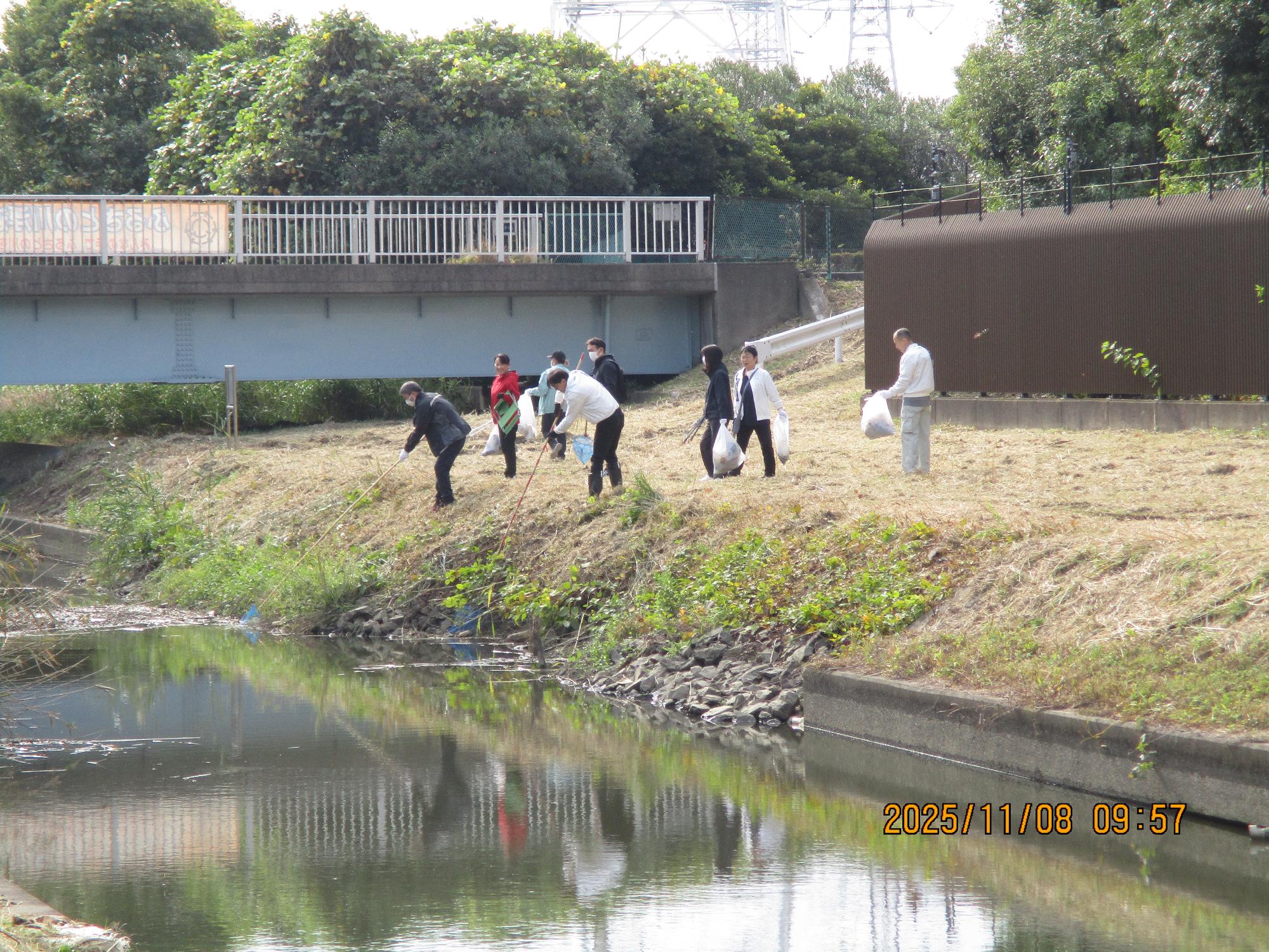 川に浮遊しているごみを網を使って拾っている写真