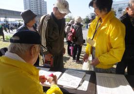 黄色い上着を着た会員2名と右手の握力を測っている男性の写真