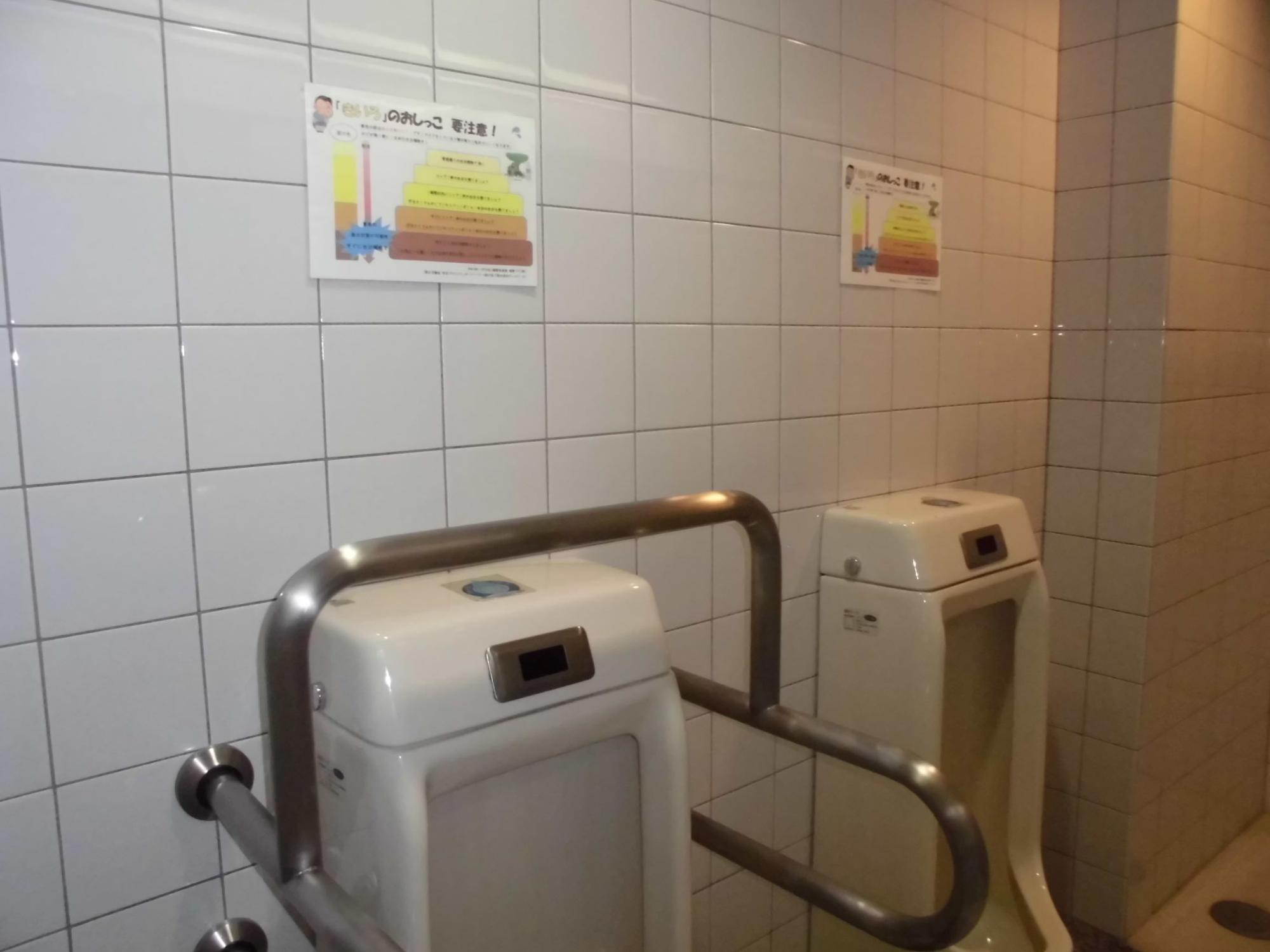 男性トイレの小便器の上に尿の色で脱水症状チェック表が掲示されている写真