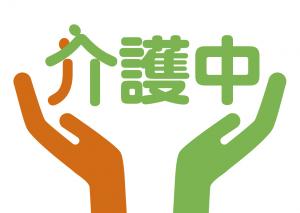 オレンジ色の左手と緑色の右手で介護中の文字を支えているイメージの介護マーク