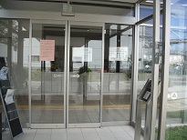 透明ガラスの両開き自動ドアが設置された施設入り口の写真