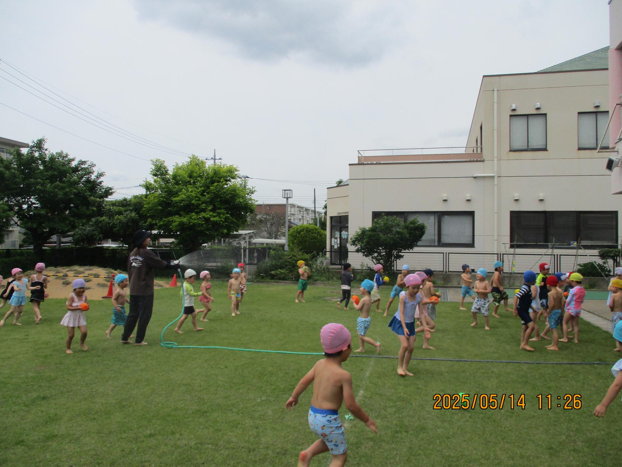 園庭で水遊びの