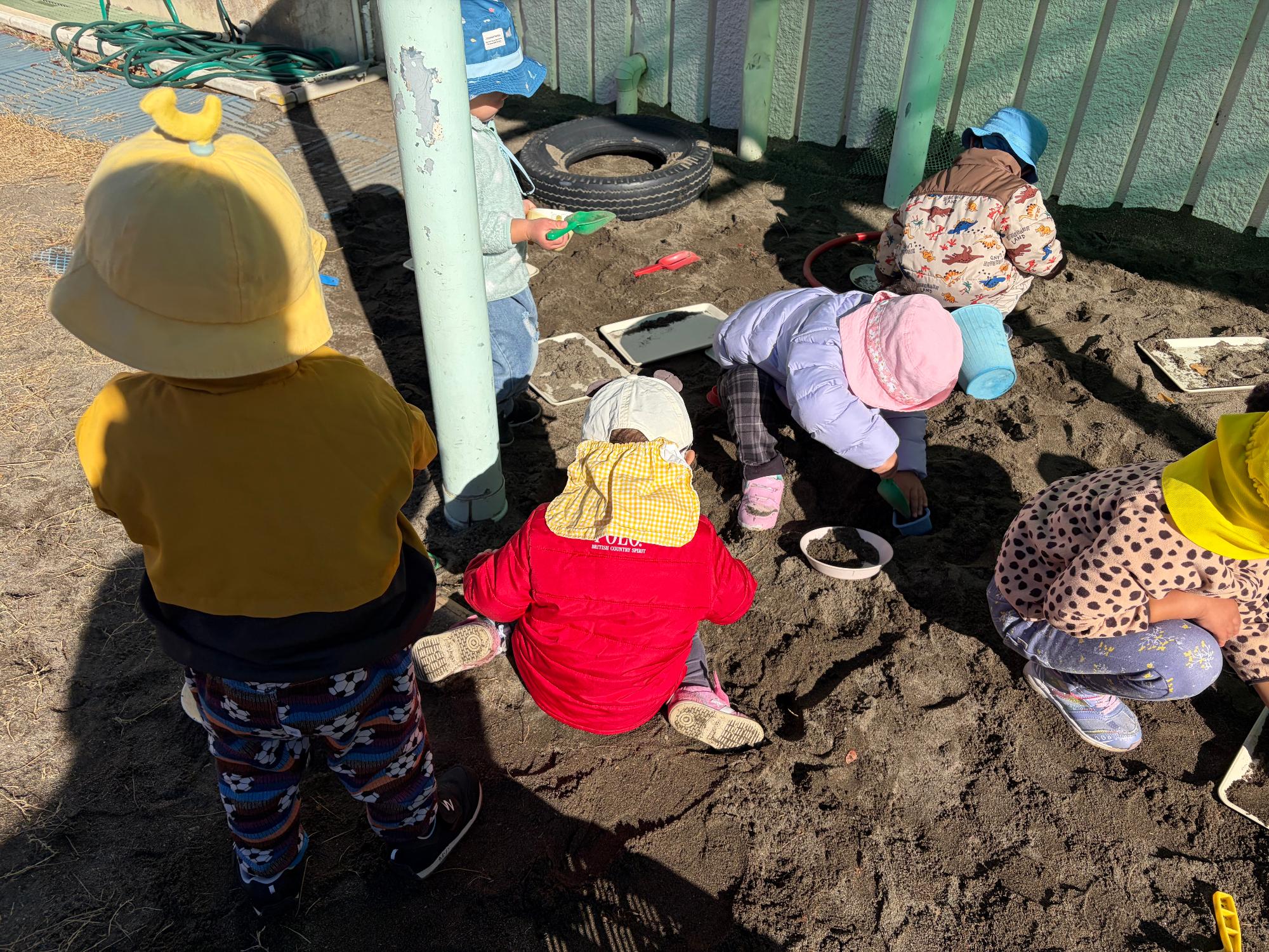 0,1歳児クラスが砂場遊びをしているところ