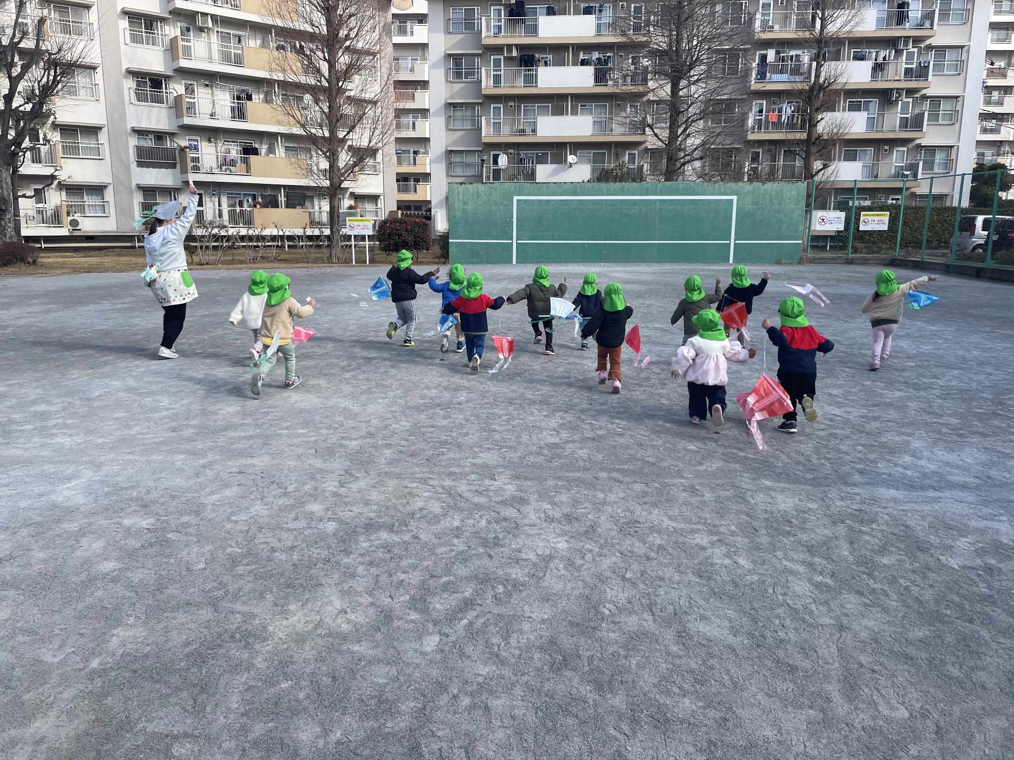 2歳児クラスが凧揚げをしている様子