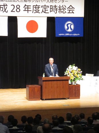 「平成28年度定時総会」と書かれた横断幕の下の演壇に立っている市長が挨拶を行っている様子の写真