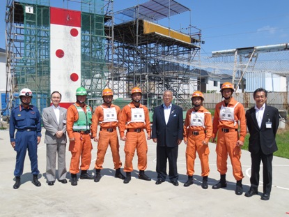 オレンジ色のヘルメットに作業着を着た5名の消防団員と青色の制服を着た1名の消防団員、2名のスーツを着た男性と市長が横一列に並び記念撮影をしている写真