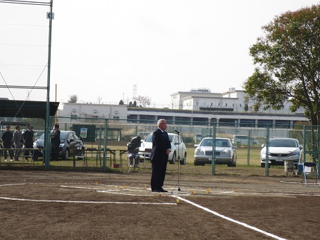 三郷市長が番匠免運動公園のグラウンドに立ち、設置されたマイクに向かって開会式のあいさつの言葉を述べている写真