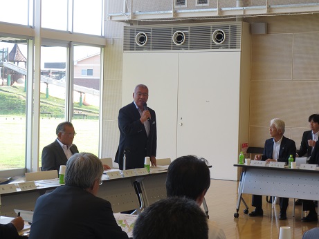 着席している関係者の方々が聞いているなか、席から立ち上がり挨拶を行っている市長の写真