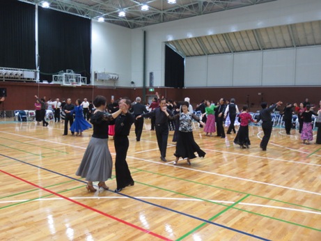 様々なカラフルな色の衣装を身にまとった女性と男性がダンスを踊っている様子の写真