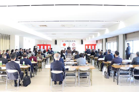 表彰式会場に集まった受賞者の方々が着席され、演台であいさつする市長の写真