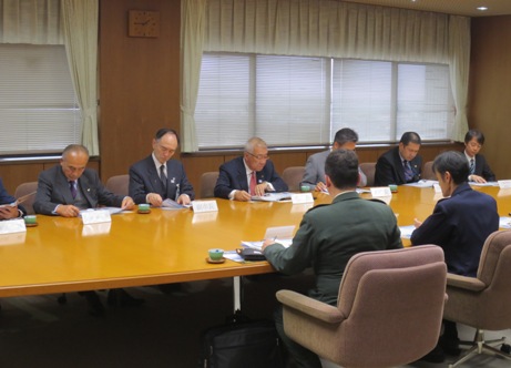 横長のテーブルの席に市長をはじめ関係者が並んで座り、向かい合って座っている自衛官の方に説明を受けている様子の写真