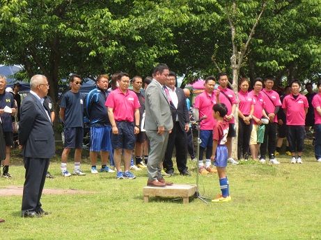 グレーのスーツを着た男性に向かって選手宣誓を行う吉川武蔵野サッカースポーツ少年団キャプテンと、その様子を見守る三郷市長と関係者の写真