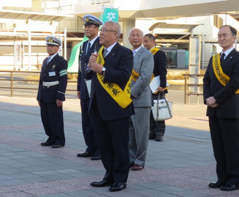 黄色のタスキを肩に掛け挨拶を行っている市長の写真
