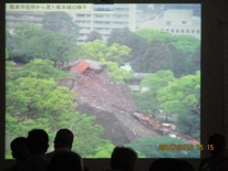 スクリーンに映し出された土砂崩れの画像を見ている参加者の後ろ姿の写真