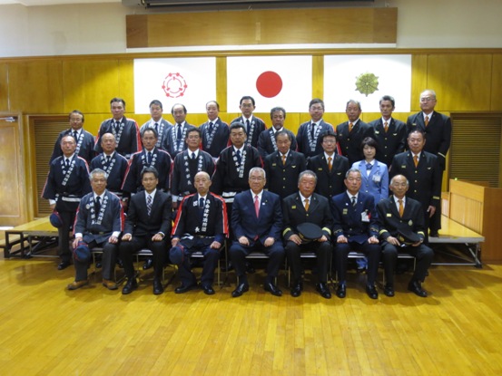 市長を挟んで西会津町消防団の皆さんと消防職員の方々が並んでいる記念写真