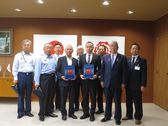 両手で表示証を持っている2名の代表者が中央に立ち、市長や6名の消防署の関係者が集まっている記念写真