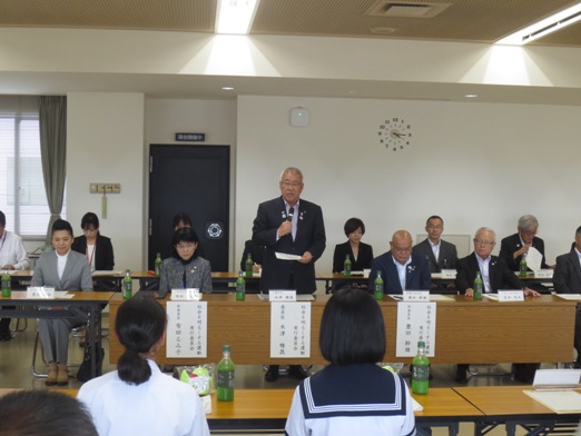 子供たちと関係者が向かい合って座っている席の中央で、挨拶を行っている市長の写真