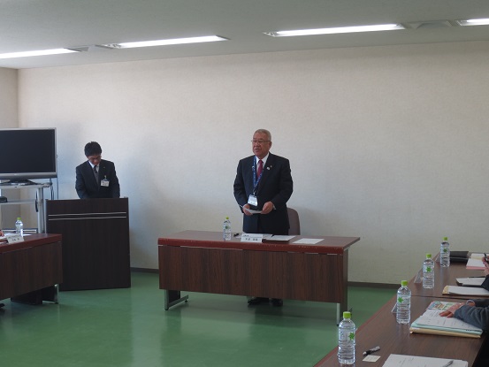 部屋中央に設置された席から立ち上がり挨拶を行っている市長の写真