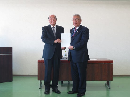 市長の席の前で佐藤会長と市長が並んで立ち諮問書を一緒に持っている写真