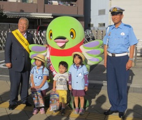 市長と警察署長の間にマスコットキャラクターかいちゃんと3名の子供たちが並んでいる写真