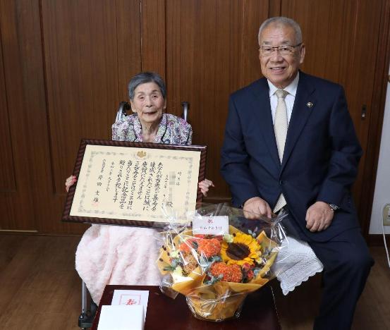 百歳を迎えられたかたと市長が並んで座っている写真