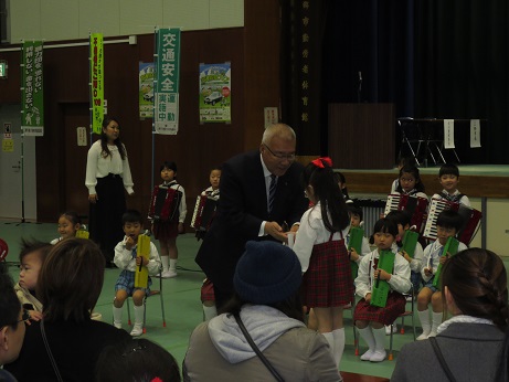 園児を代表して髪の毛を赤色のリボンで結んだ女児が市長からお礼を言われている写真
