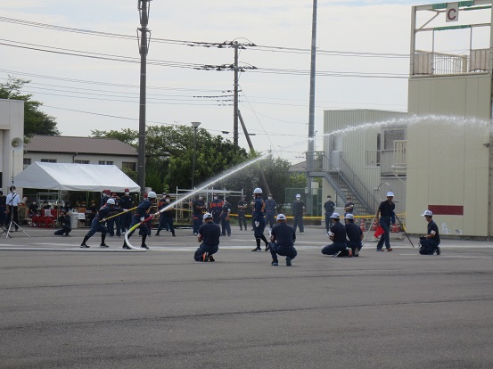 三郷市消防団の団員がホースから放水しながら操法を披露している写真