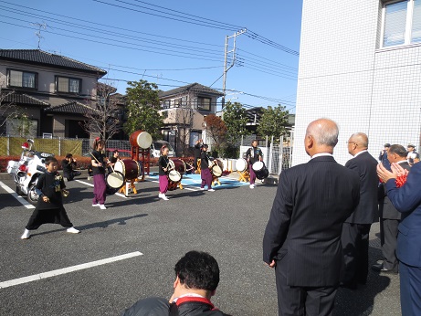 市長をはじめ警察関係者の方が見守るなか、太鼓俱楽部「源流」の方々が太鼓を持ち演奏を行っている様子の写真