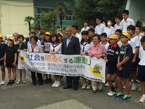 地域の方々と小中学生の子供たちが「社会を明るくする運動」と書かれた横断幕を持ち中央に市長が立って並んでいる写真