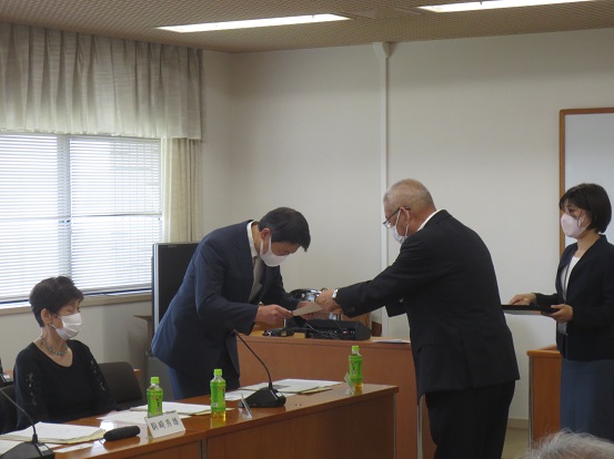 椅子に着席している関係者が見守る中、市長と関係者が向かい合って委嘱書の交付をしている写真