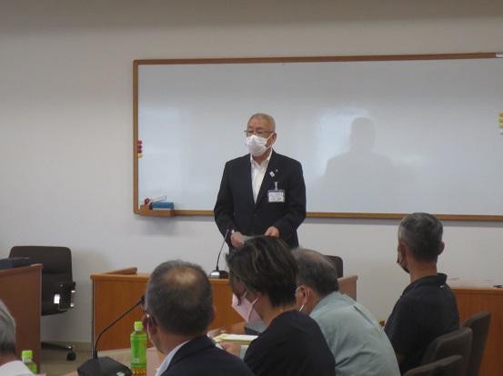ホワイトボードが設置されている部屋で、関係者たちが着席しているなか、正面に立って話をしている市長の写真
