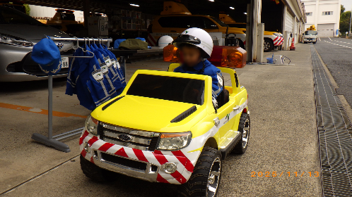 ミニパトロールカーに乗る子供の写真