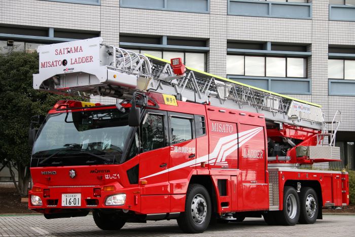 車体に「三郷市消防本部」「MISATO LADDER」と書かれた真っ赤な車体のはしご車を右斜め前方から写した写真