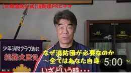 紺色の法被を着用した俳優の村田雄浩さんがPRビデオのナレーションを行っている写真（【三郷消防公式消防団PRムービー】なぜ消防団が必要なのか～全てはあなた自身のために～（YouTubeのサイトへリンク））