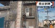 消防服を着た隊員が、訓練用の建物の2階にはしごを使って上っている救出訓練の写真