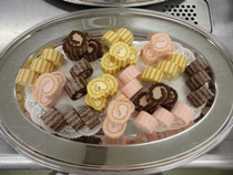 大きな丸い皿に盛り付けられたプチケーキ（チョコ、ストロベリー、カスタード）の写真