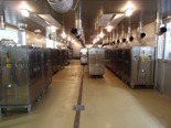 3列に並んだ機械を前方から写した給食センターの室内の写真