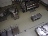 給食センターの室内に置かれたいろいろな種類のアルミ容器を上から写した写真
