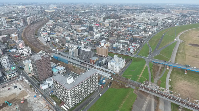 駅周辺がビル群や民家で埋まっている様子を上空から撮った写真