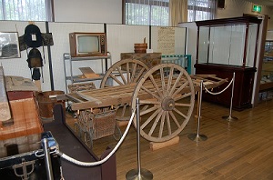 荷車やテレビ、タンスなど当時使用していた道具などが展示されている資料館内の写真