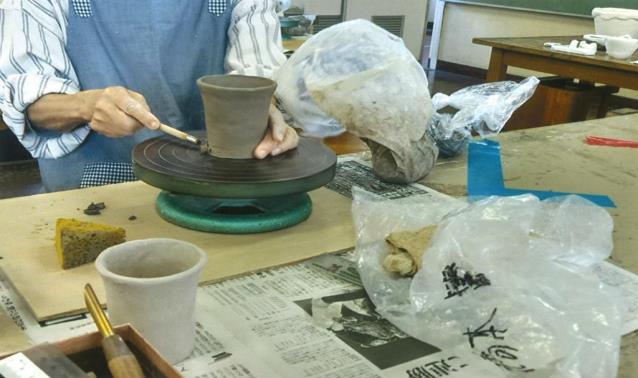 陶芸でろくろをまわしコップをつくっている手元を写した写真
