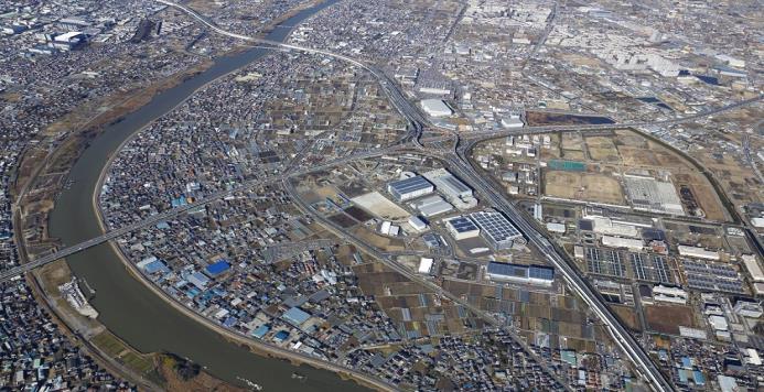 近くを大きな河川が流れており、四方から伸びた道路がインターチェンジで繋がっている写真