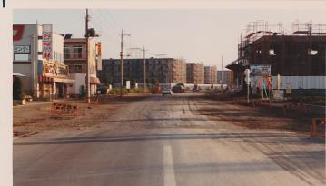 道路の先に建設されている早稲田団地と、手前の道路に黄色と黒のバリケードが立ててある写真