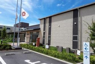 青空の下で撮影された、障害者専用の駐車場が建物横に設置されているわくわくライブラリーの外観写真