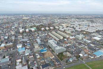 周囲に民家が立ち並んでいる団地を上空から撮影した写真