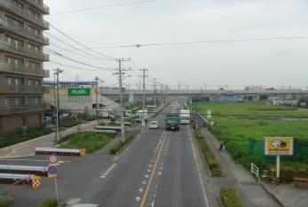 道路の左側にマンションが建っており、右側は空き地になっている開発中の中央地区の写真