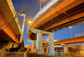 令和3年（2021年）に撮影された、等間隔に設置された橋脚が高速道路を支えており、その上で道路照明が灯っている夜の三郷インターチェンジの写真
