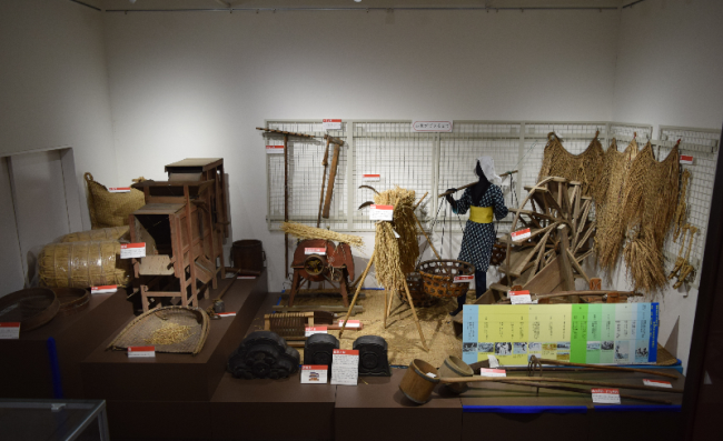 もんぺを着た人形や、作業に使う道具などがある「お米ができるまで」展示物の写真
